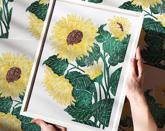 May include: A framed print of a botanical illustration featuring three sunflowers with green leaves and stems on a white background.