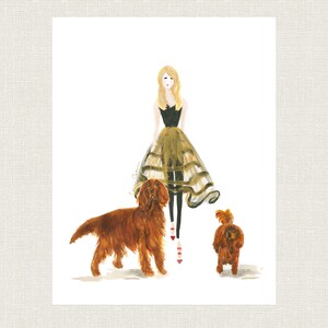 May include: A watercolor illustration of a woman in a black top and a gold tulle skirt, standing with two dogs. The woman has blonde hair and is wearing red shoes. The dogs are both brown and white.