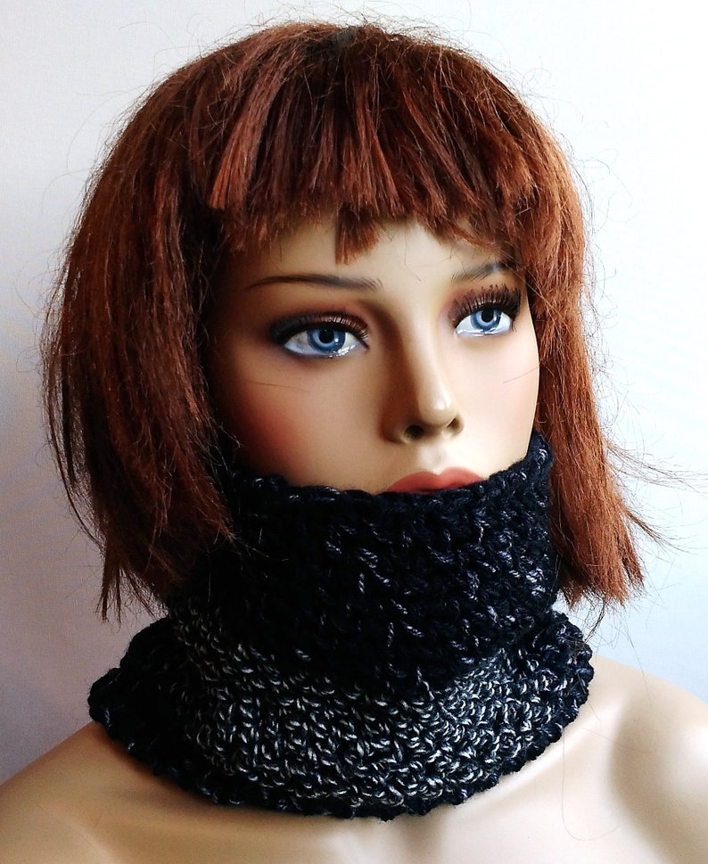 May include: A black and silver crocheted neck warmer. The neck warmer is made with a chunky yarn and has a simple, modern design.
