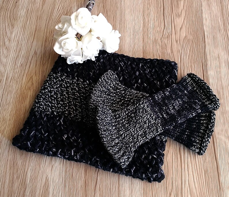 May include: A black and silver knitted neck warmer and matching fingerless gloves. The neck warmer has a textured pattern and the gloves have a ribbed pattern.