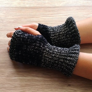 May include: A pair of black and grey fingerless gloves made of knitted fabric.