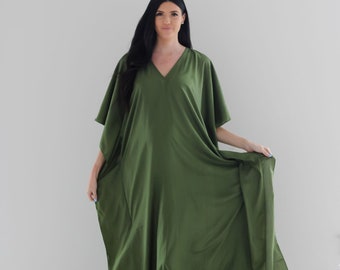 May include: A long, flowing green kaftan dress with a V-neckline and short sleeves. The dress is made of a soft, lightweight fabric and has a relaxed fit.