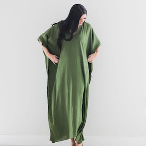 May include: A long, flowing green maxi dress with a V-neckline and short sleeves. The dress is made of a soft, lightweight fabric and has a relaxed fit.