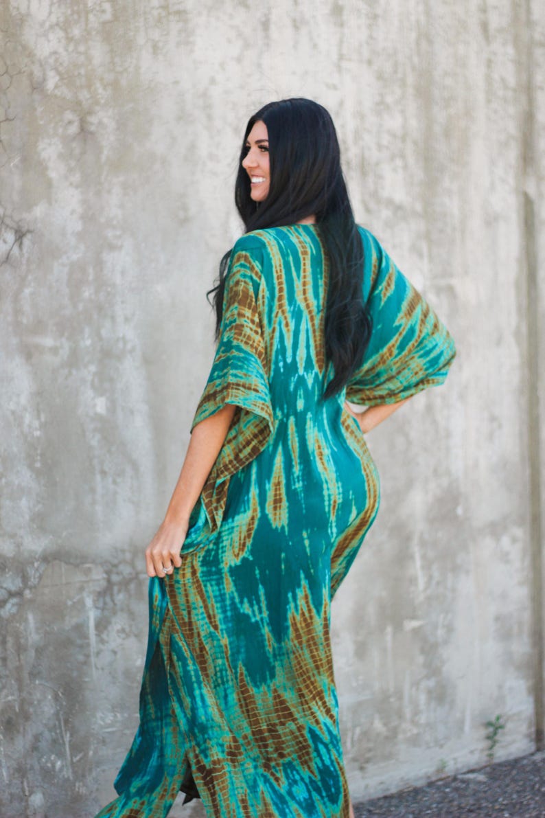 May include: A long, flowing teal and brown tie-dye maxi dress with a V-neckline and wide sleeves.