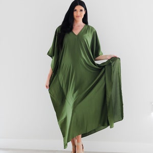 May include: A long, flowing green maxi dress with a V-neck and short sleeves. The dress is made of a soft, silky fabric and has a relaxed fit.
