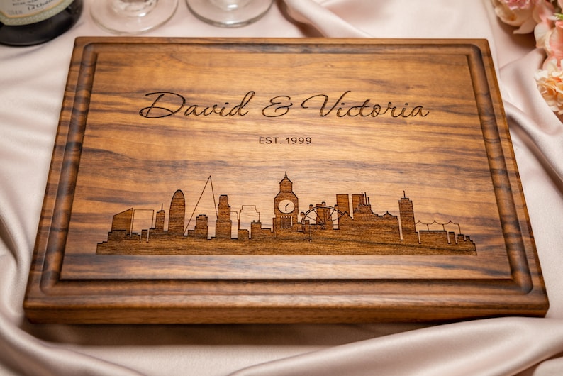 Personalized engraved cutting board. Handmade from natural hardwood, not stained. United Kingdom skyline, over 50US cities. Line 1 names or any text, Line 2 date or any text.