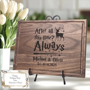May include: A rectangular dark wood cutting board with a juice groove, engraved with a deer silhouette, stars, a wand, and the text: After all this time? Always, Michael & Olivia, Est. 01.18.2025. A small card reads: Happy Wedding Day! From: Edward & Maria.