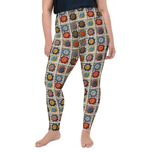 May include: High-waisted leggings featuring a colorful, patchwork-style design. The pattern includes squares with floral-like motifs in shades of red, orange, yellow, blue, and brown, set against a cream background. The leggings are made of a stretchy material.