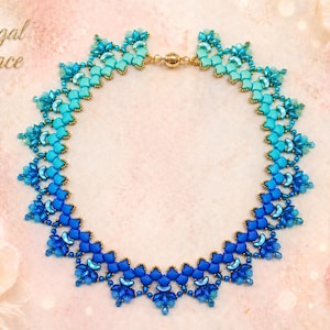 Puede incluir: Un collar de cuentas con un degradado de tonos azules, desde turquesa claro hasta índigo profundo. El collar presenta un diseño floral con detalles dorados y un cierre. El texto "Regal Grace" es visible en la esquina superior izquierda.