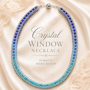 May include: A beaded necklace featuring a gradient of blue and turquoise crystal beads interspersed with small silver beads. The text "Crystal WINDOW NECKLACE" and "Designed by SHIRA RENAN" is centered within the oval shape of the necklace.