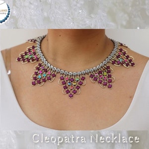 Op de afbeelding: Een zilveren en paarse kralenketting met een geometrisch ontwerp. De ketting heet "Cleopatra ketting".