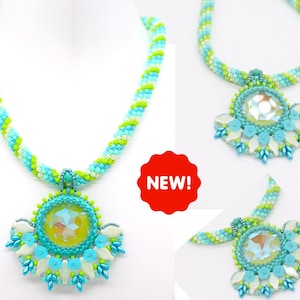 Puede incluir: Un collar de cuentas turquesa y verde con un gran colgante de cristal iridiscente. El colgante está rodeado de cuentas blancas y turquesas en un diseño floral. El collar es nuevo.