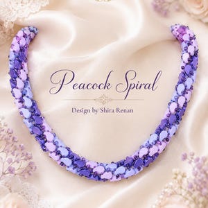 May include: A handcrafted necklace in shades of purple, lavender, and blue, with a spiral design. The necklace is displayed on a satin surface, with the text "Peacock Spiral" and "Design by Shira Renan". The HobbyLand Art logo is visible.