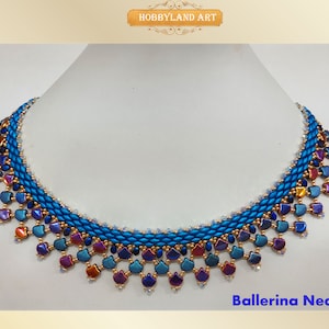 Può includere: Una collana di perline blu e dorate con una frangia a cascata di perline a forma di cuore iridescenti. La collana si chiama "Ballerina Necklace".