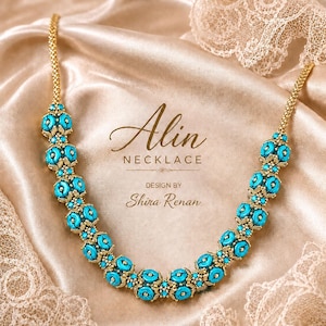 May include: A necklace featuring a series of bright turquoise beads interspersed with small gold-toned metallic accents. The text Alin NECKLACE DESIGN BY Shira Renan is centered above the curved jewelry piece on a smooth, light-colored fabric.