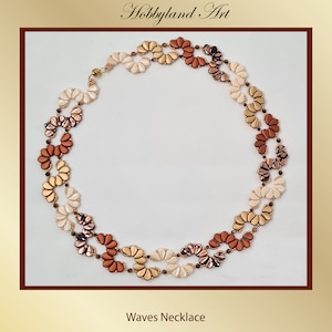 May include: A multi-strand necklace made of small, iridescent beads in shades of gold, brown, and white. The beads are arranged in a wave-like pattern, creating a delicate and elegant look. The necklace is called "Waves Necklace".