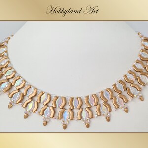 Può includere: Una collana di perline dorate e bianche iridescenti con un motivo ondulato. La collana ha un design delicato e femminile.
