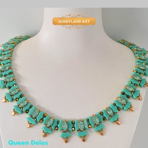 Può includere: Una collana di perline turchesi e dorate con un design geometrico. La collana si chiama "Queen Delos" ed è esposta su un manichino bianco.