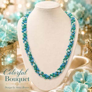 May include: A beaded necklace with a floral design, displayed on a white mannequin. The necklace features a mix of blue, teal, and white beads, with gold accents. The text "Colorful Bouquet" and "Design by Shira Renan" are visible.