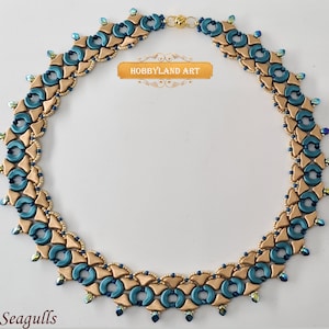 Può includere: Una collana di perline dorate e turchesi con un motivo geometrico. La collana è realizzata con piccole perline rotonde e ha un aspetto delicato e femminile. Il testo "HOBBYLAND ART" è visibile nell'immagine.