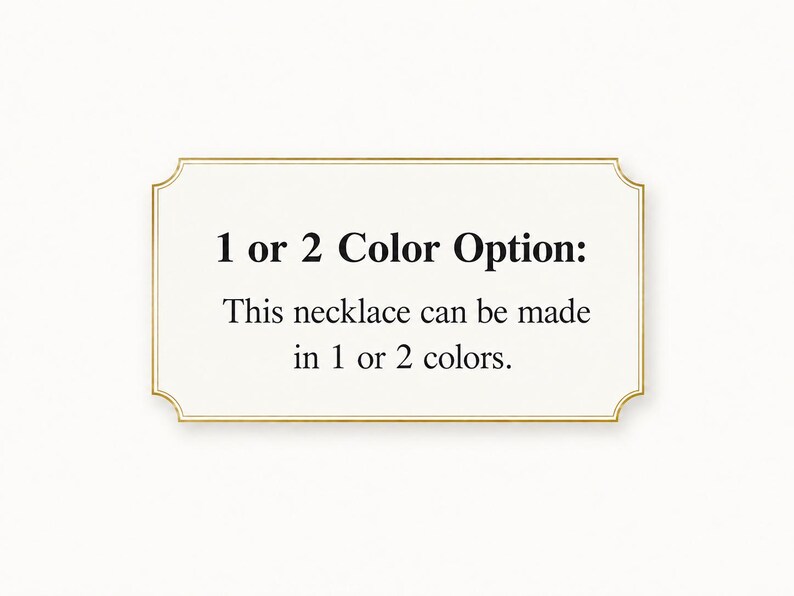 May include: A rectangular sign with a gold border and text that reads "1 or 2 Color Option: This necklace can be made in 1 or 2 colors." The sign is on a white background.