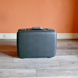 May include: A black vintage suitcase with a silver handle.