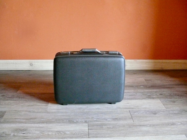 May include: A black vintage suitcase with a silver handle.