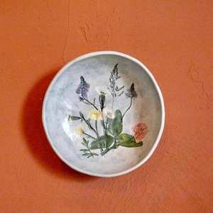 May include: A white ceramic mug with a black handle and the text "But First, Coffee" in a handwritten style. The mug is on a white surface. The mug is 4 inches tall.