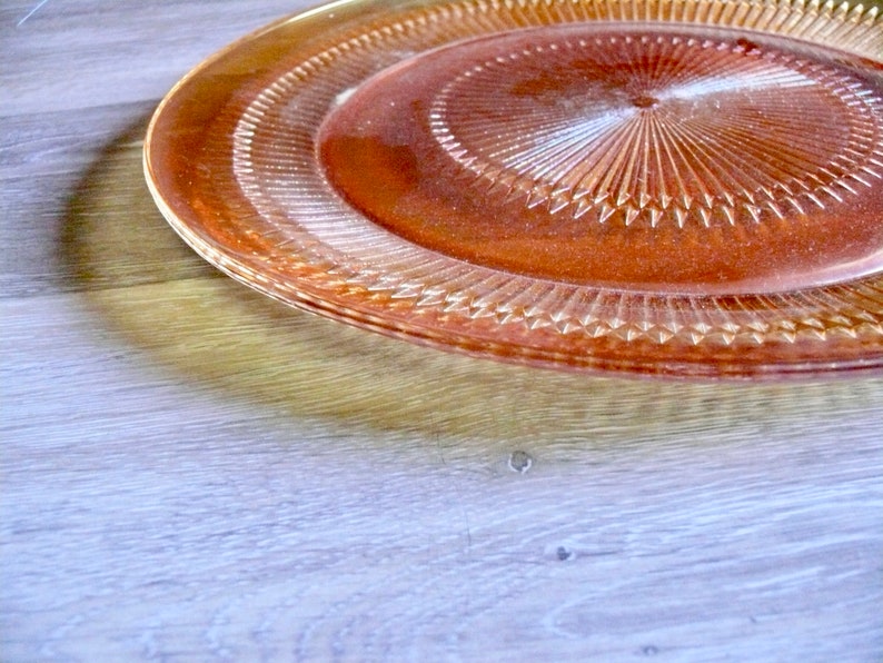 Puede incluir: Un plato de servir grande de vidrio transparente con un patr&oacute;n de diamante. El plato tiene un tono ligeramente &aacute;mbar y es perfecto para servir aperitivos, aperitivos o postres.