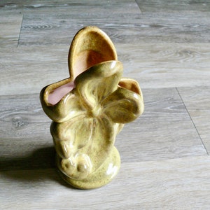 K&ouml;nnte beinhalten: Eine Vintage-Vase aus hellgr&uuml;ner Keramik mit einer einzigartigen, organischen Form. Die Vase hat eine strukturierte Oberfl&auml;che und einen hellrosa Innenraum. Das Design &auml;hnelt einer stilisierten Blume oder einem Blatt und verleiht jedem Raum einen Retro-Charme.