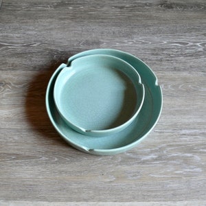 May include: Two round, light blue ceramic bowls, one nested inside the other.