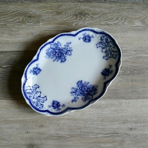 May include: A white oval serving platter with a blue and white floral design. The platter has a scalloped edge.