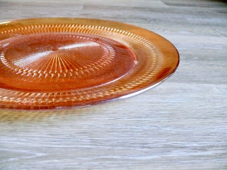 Puede incluir: Un plato de servicio grande de vidrio &aacute;mbar con un patr&oacute;n decorativo de c&iacute;rculos conc&eacute;ntricos.