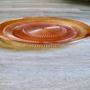 Puede incluir: Un plato de servir de vidrio &aacute;mbar transparente con un patr&oacute;n decorativo de c&iacute;rculos conc&eacute;ntricos.