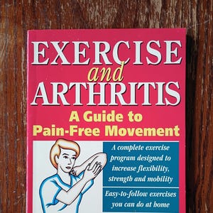May include: A book titled "EXERCISE and ARTHRITIS" with a red cover and white text. The book features an illustration of a person exercising and promises a guide to pain-free movement. It includes information on exercises for flexibility and strength.