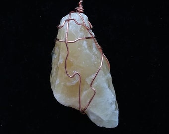 May include: A raw, yellow-white crystal wrapped in copper wire, hanging from a black cord. The crystal is a natural, rough shape and has a unique, organic look.
