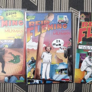May include: Three comic books with colorful covers featuring the title "Reid Fleming, World's Greatest Milkman". The covers depict a man in a milkman uniform, a man in a chef's uniform, and a man in a bar setting.