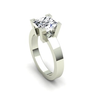 May include: A silver engagement ring with a square-shaped diamond.
