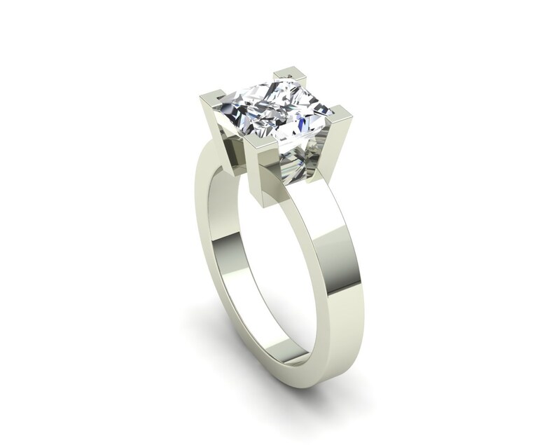 May include: A silver engagement ring with a square-shaped diamond.