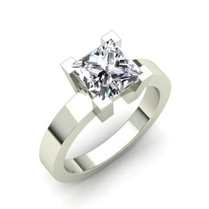 May include: A silver engagement ring with a square-shaped diamond.