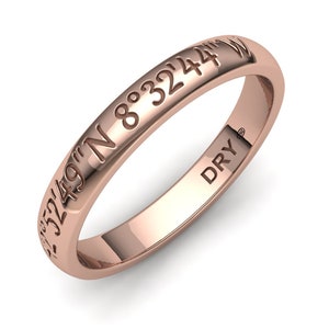 May include: A rose gold band ring with the coordinates "32°49'N 8°32'44"W" engraved on the outside and "DRY" engraved on the inside.