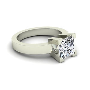 May include: A silver ring with a square-shaped diamond set in a prong setting.