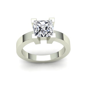 May include: A silver engagement ring with a square-shaped diamond.
