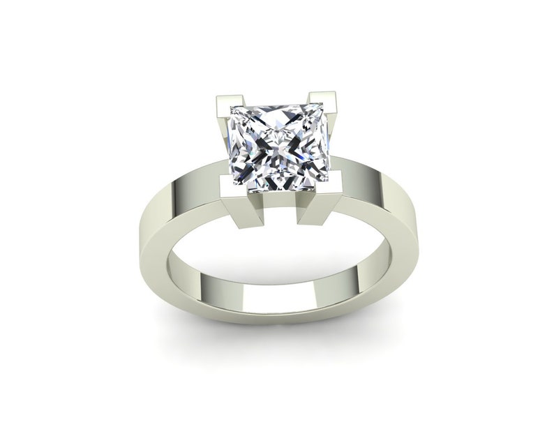 May include: A silver engagement ring with a square-shaped diamond.