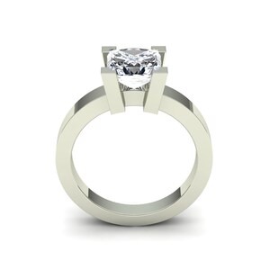 May include: A silver ring with a large, clear, square-shaped diamond set in a simple, modern design.