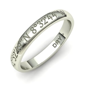 May include: A silver ring with the coordinates "32°49'N 8°32'44"W" engraved on the band. The inside of the ring is stamped with "DRY".
