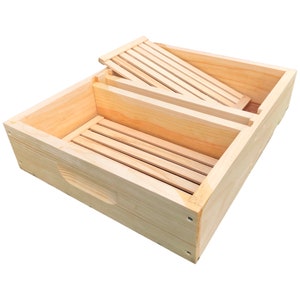 May include: A wooden beehive box with a removable divider, allowing for separate compartments. The box is made of natural wood with a light brown color.