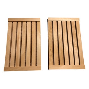 May include: Two wooden cutting boards with a slatted design. The boards are made of light brown wood and have a natural finish.