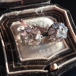 May include: A pair of antique diamond earrings with a cluster of rose cut diamonds set in silver. The earrings are in a vintage jewellery box.