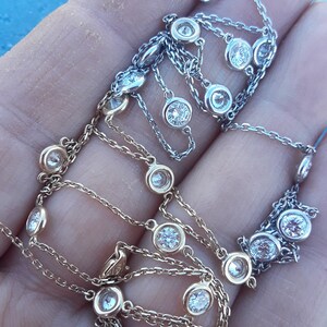 May include: Two delicate necklaces with round diamond accents. One necklace is gold and the other is silver.